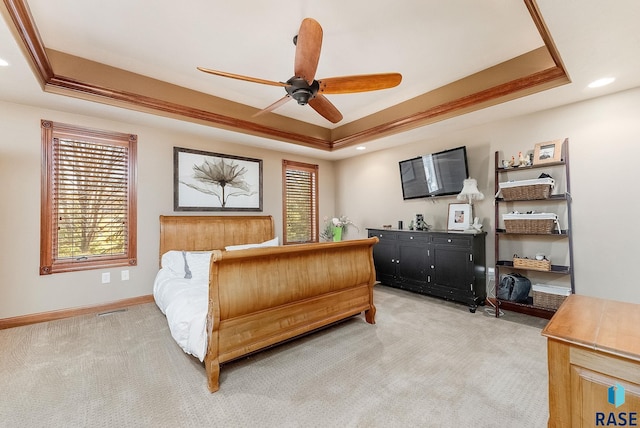 bedroom with light carpet, visible vents, and a tray ceiling