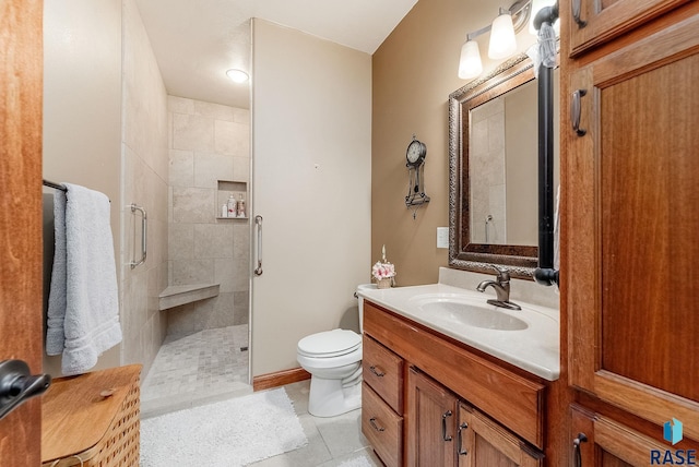 bathroom with toilet, vanity, and a tile shower