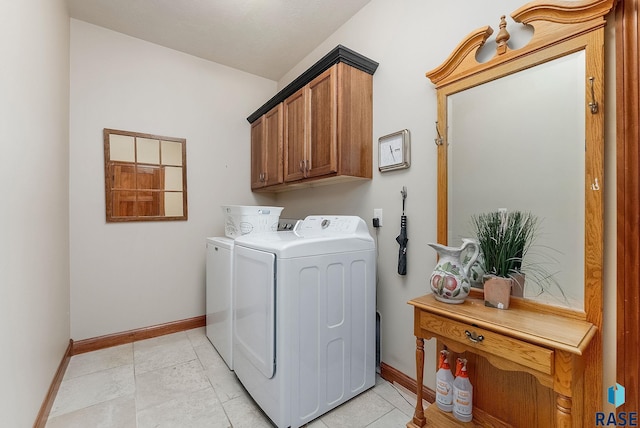 laundry room with cabinet space, washing machine and dryer, and baseboards