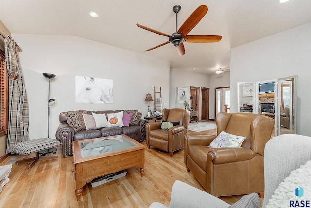 living area with lofted ceiling, light wood-style floors, and ceiling fan