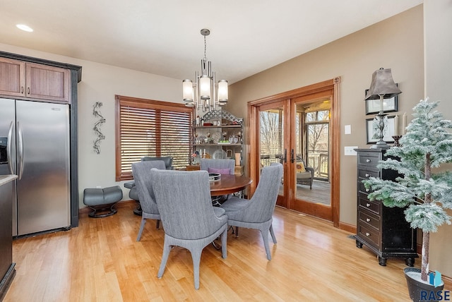 dining room with a wealth of natural light, french doors, and light wood-type flooring