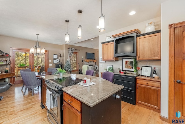 kitchen with a kitchen island, light wood-style floors, an inviting chandelier, stainless steel electric range, and hanging light fixtures