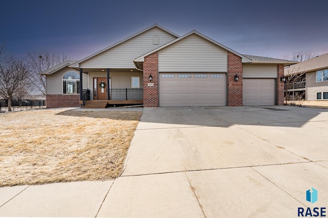 ranch-style house featuring a garage, brick siding, covered porch, and driveway