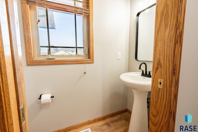 bathroom with baseboards and wood finished floors