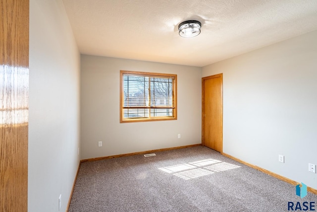 empty room featuring visible vents, a textured ceiling, baseboards, and carpet floors