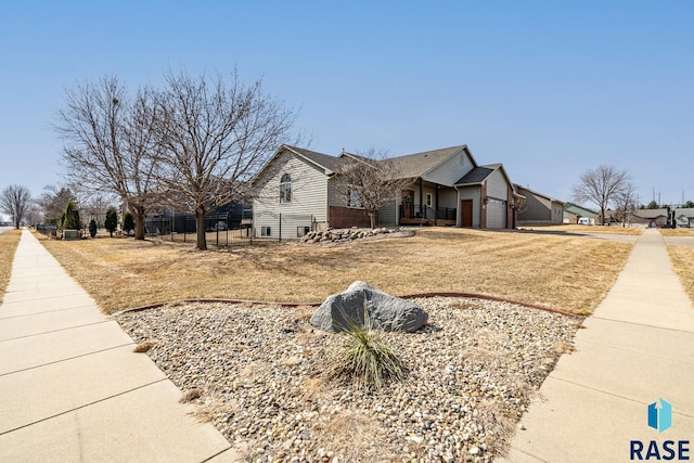 view of home's exterior with a garage, a lawn, driveway, and fence