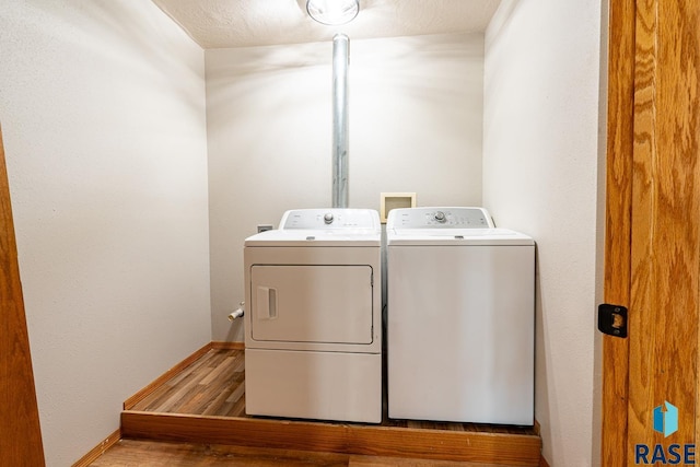 laundry room with laundry area, wood finished floors, independent washer and dryer, and baseboards