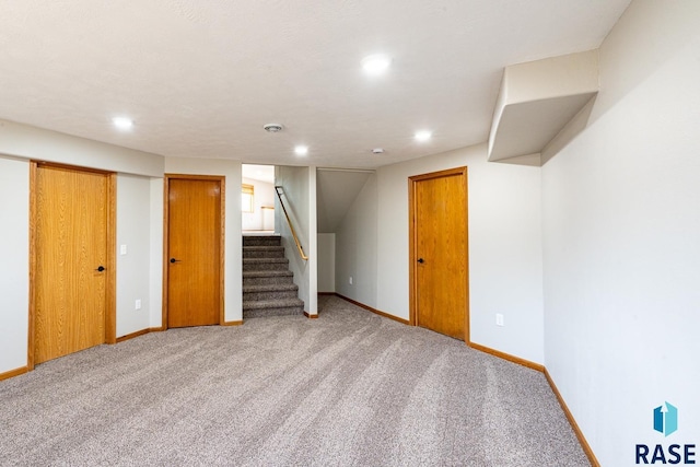 finished basement featuring stairway, baseboards, and carpet flooring