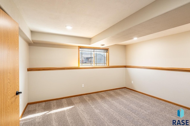 spare room featuring carpet and baseboards