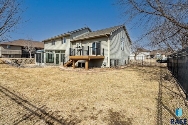 rear view of house with a wooden deck, fence private yard, stairs, a lawn, and a sunroom