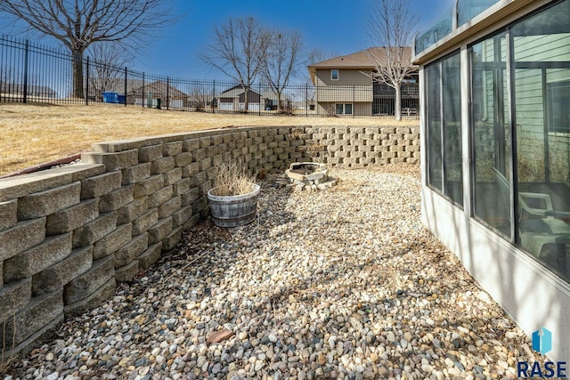 view of yard with a residential view, an outdoor fire pit, and fence