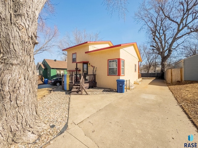 view of front facade with fence and stucco siding