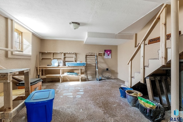 below grade area featuring a textured ceiling and stairs