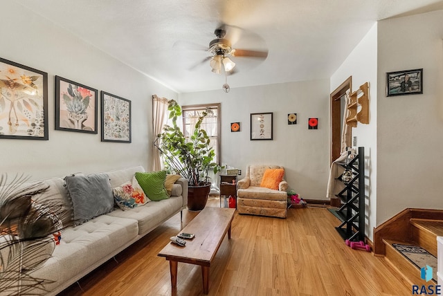 living area with light wood finished floors, baseboards, and a ceiling fan