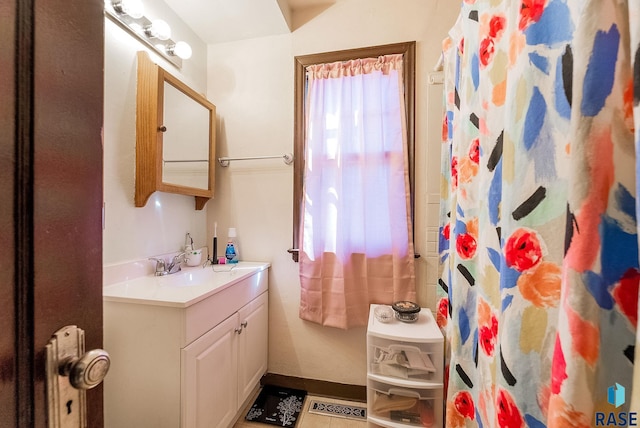 bathroom with vanity, curtained shower, and baseboards