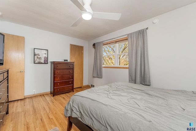 bedroom featuring baseboards, light wood-style floors, and ceiling fan