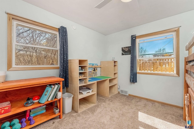 interior space with visible vents, multiple windows, baseboards, and a ceiling fan