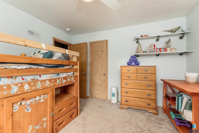 bedroom with visible vents, light colored carpet, and a ceiling fan