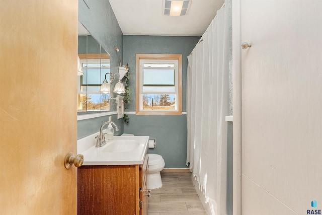 full bath with vanity, a shower with curtain, baseboards, wood finish floors, and toilet