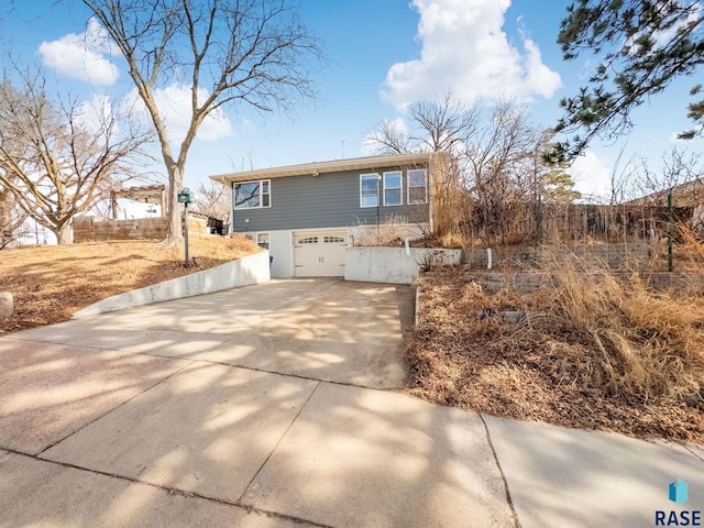 view of property exterior with driveway, a garage, and fence