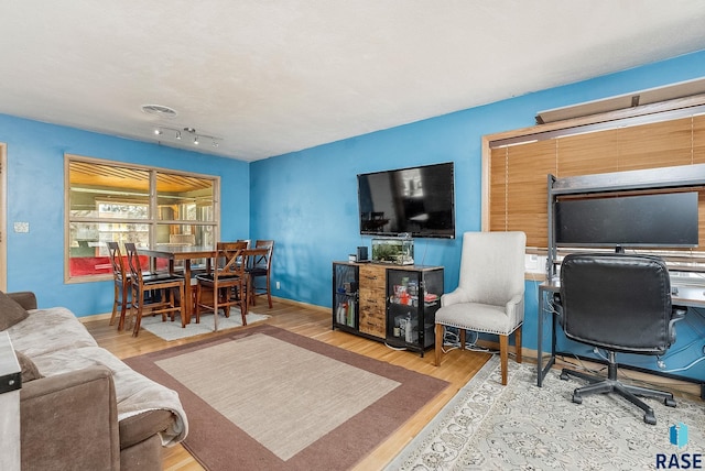 living room with visible vents, baseboards, and wood finished floors