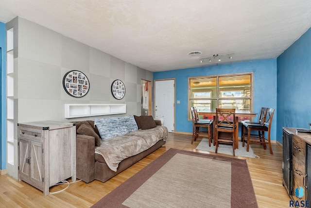 living room with baseboards and light wood-type flooring