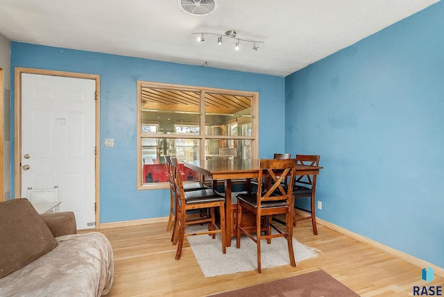 dining room featuring wood finished floors, visible vents, and baseboards