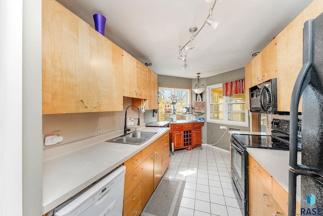 kitchen with light tile patterned floors, a sink, black appliances, light countertops, and decorative light fixtures