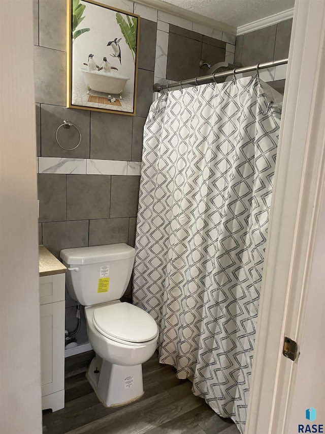 bathroom with a shower with shower curtain, tile walls, toilet, and wood finished floors