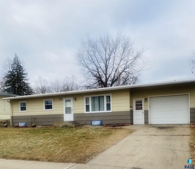 ranch-style house with a garage, a front yard, driveway, and entry steps