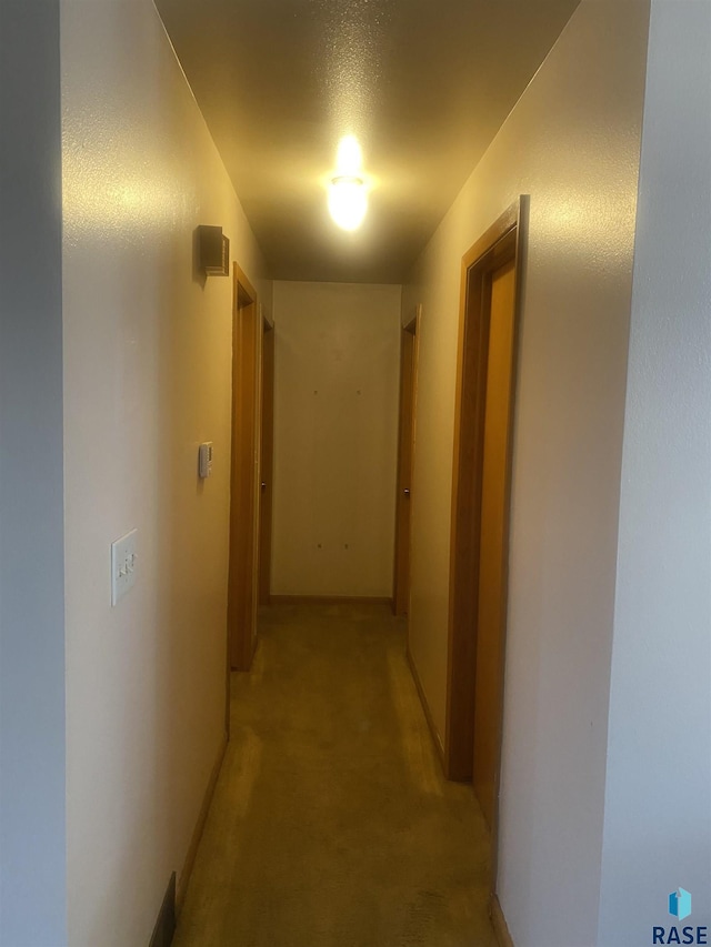 hall with light colored carpet and baseboards