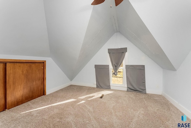 additional living space with carpet flooring, baseboards, lofted ceiling, and a ceiling fan