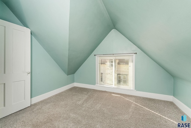 additional living space featuring vaulted ceiling, carpet, and baseboards