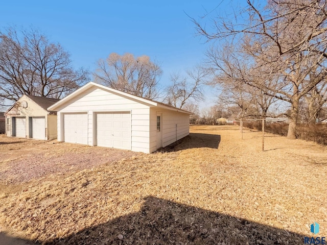 view of side of property with a garage and an outbuilding