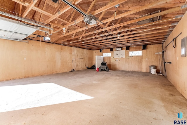 garage featuring electric panel and a garage door opener