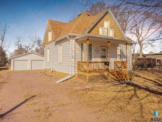 bungalow featuring a detached garage, a porch, fence, roof with shingles, and an outdoor structure