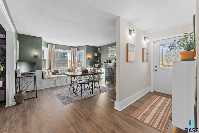 entryway with a textured ceiling, baseboards, and wood finished floors