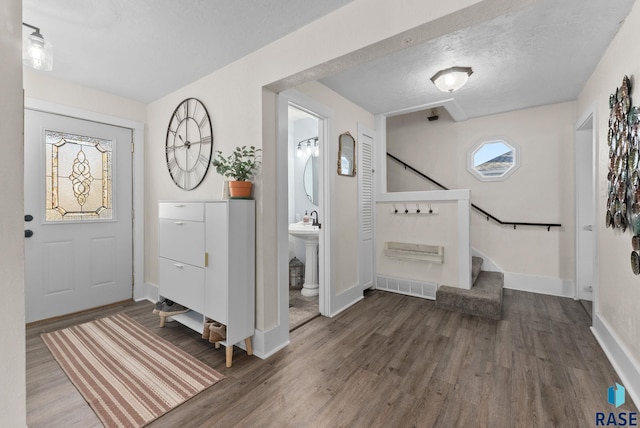 entryway featuring stairway, wood finished floors, visible vents, and a textured ceiling