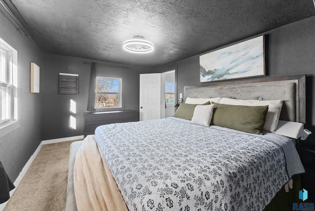 bedroom with baseboards, a textured ceiling, carpet flooring, and a textured wall