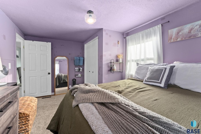 bedroom with carpet flooring, arched walkways, a closet, and a textured ceiling