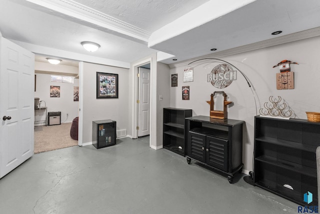 hallway with visible vents, ornamental molding, a textured ceiling, concrete floors, and baseboards