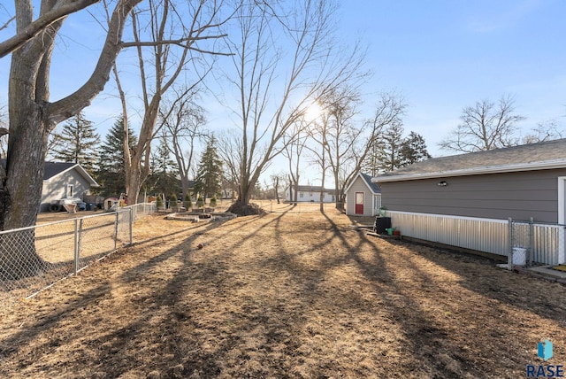 view of yard with central air condition unit and fence