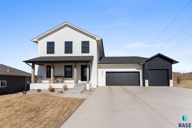 view of front of house with a porch, a garage, board and batten siding, and driveway