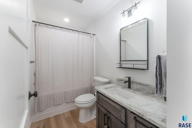 bathroom with vanity, wood finished floors, visible vents, shower / bath combo, and toilet