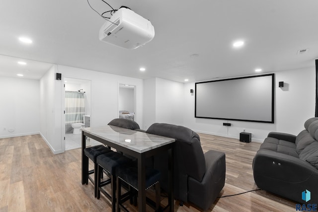 cinema room featuring recessed lighting, light wood-type flooring, baseboards, and visible vents