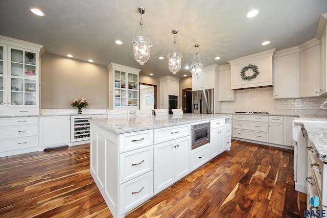 kitchen with a center island, white cabinetry, recessed lighting, stainless steel appliances, and wine cooler