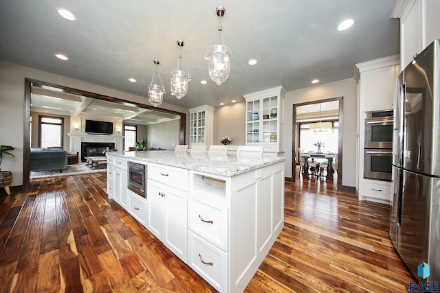 kitchen featuring white cabinetry, dark wood-type flooring, open floor plan, and appliances with stainless steel finishes