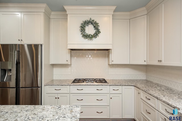 kitchen featuring decorative backsplash, white cabinets, light stone counters, and stainless steel appliances