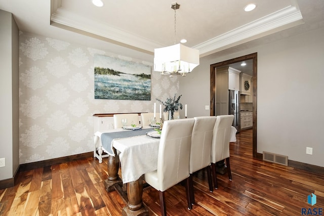 dining space with visible vents, a raised ceiling, an inviting chandelier, and wallpapered walls