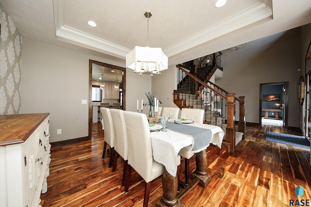 dining area featuring dark wood-style floors, a tray ceiling, stairs, crown molding, and a notable chandelier